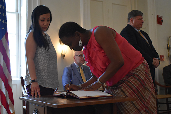 Graduate Institute student Tanya Fuller signs the College Register during Convocation.