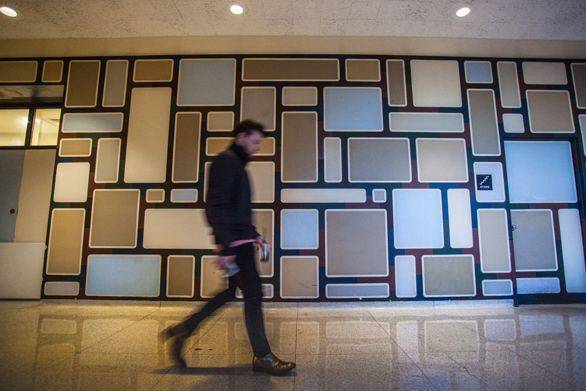 Student walking in front of unfinished Girard mural Student Center St Johns College