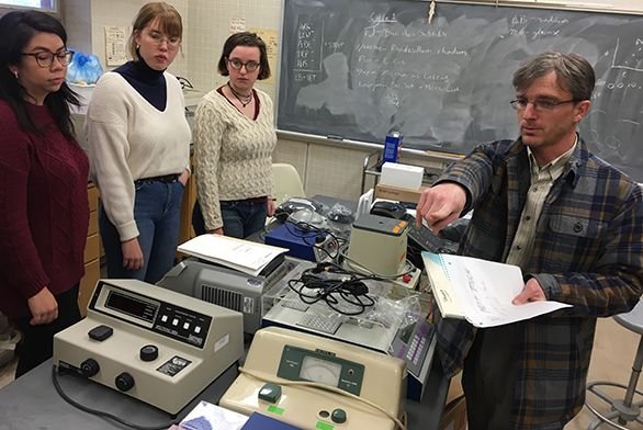 Tutors Llyd Wells discusses lab equipment with students.