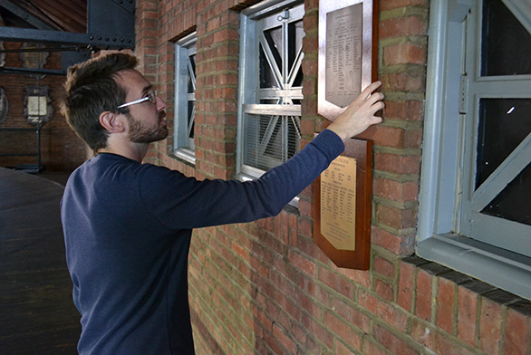 Chris Krueger looks at a plaque on the wall of Iglehart Gymnasium.