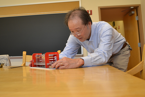 Cordell Yee works with a mechanical computer.