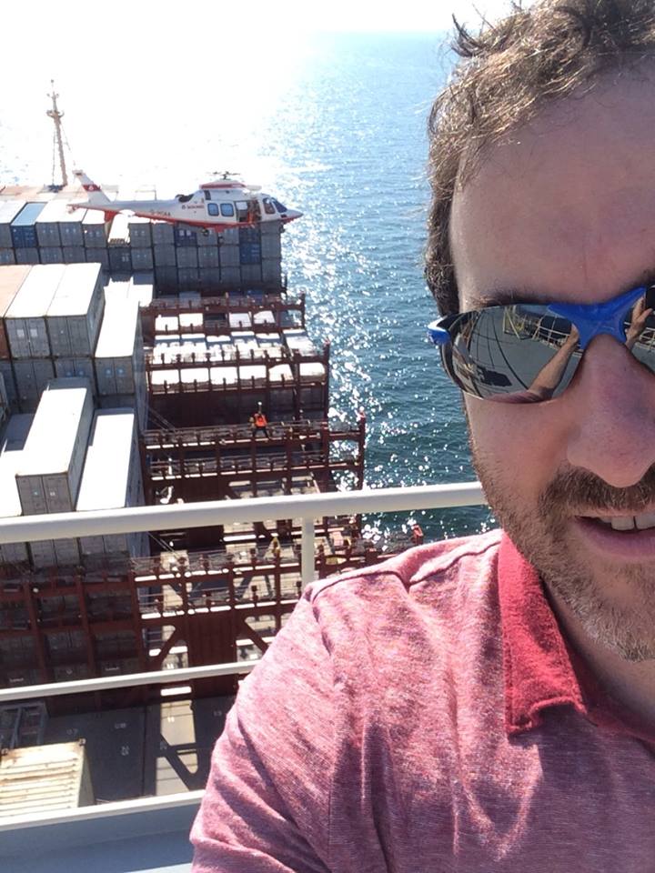 Danny Hakim stands on a cargo ship in the North Sea.