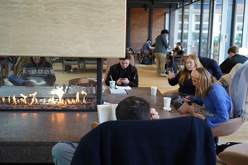 Students are hanging out by the fireplace at the fishbowl