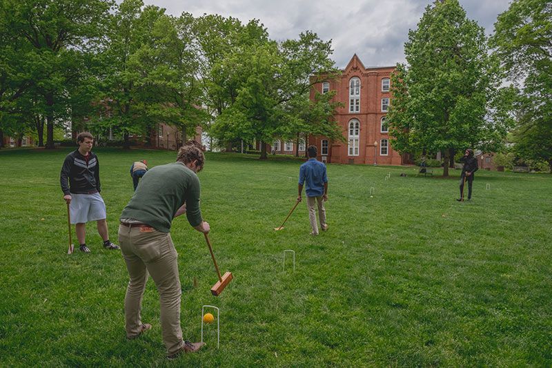 Students are playing croquet on the front lawn