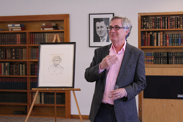 Mark Roosevelt stands with a lithograph of Frederick Douglass he donated to the college.